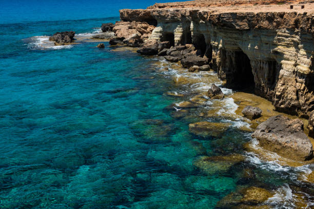 Sea caves near Ayia Napa, Mediterranean sea coast, Cyprus Sea caves (littoral caves) near Ayia Napa, Mediterranean sea coast, Cyprus. They are formed primarily by the wave action of the sea greco stock pictures, royalty-free photos & images