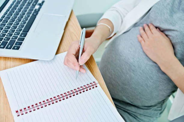 istock Pregnant woman writing in the office 957167478