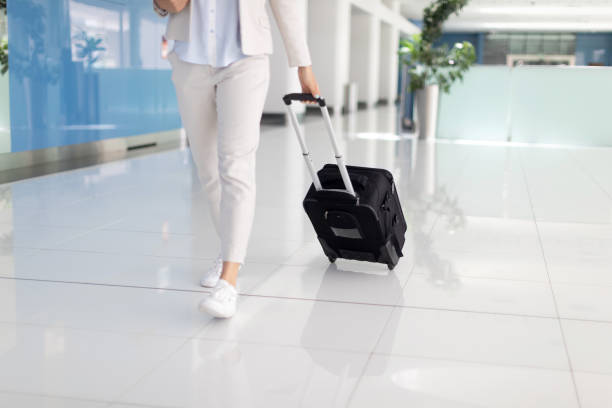 istock Low section of businesswoman pulling suitcase 957167764