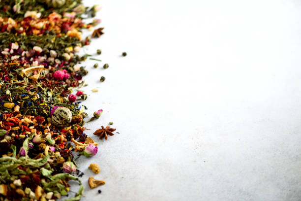 istock Close up tea background: green, black, floral, herbal, mint, melissa, ginger, apple, rose, lime tree, fruits, orange, hibiscus, raspberry, cornflower, cranberry. Assortment of dry tea, top view 957167918