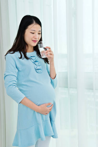 istock Pregnant woman drinking water 957169108