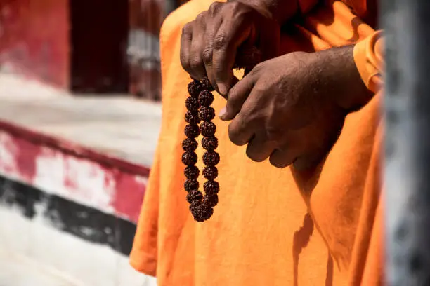 Image of a sadhu sitting in a meditation pose with beads