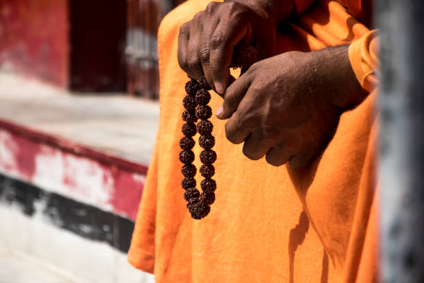 image of a sadhu sitting in a meditation pose with beads - sadhu imagens e fotografias de stock