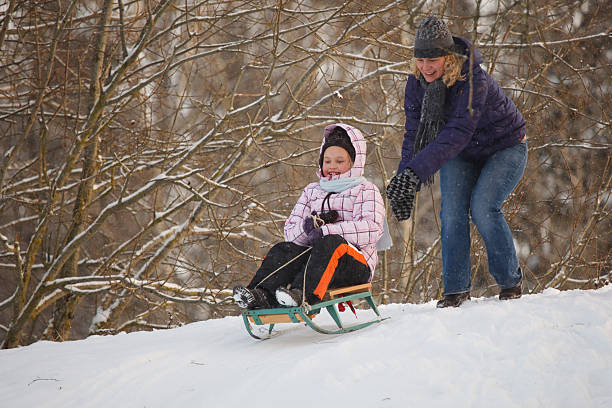 istock Mother and daughter sledging 95718186