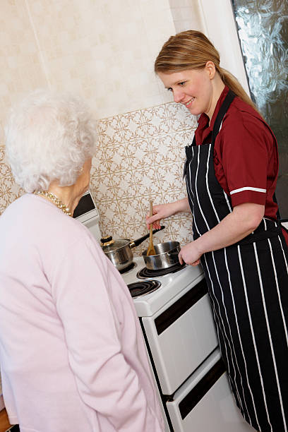 istock happy young Nurse cooking for old lady at home 95718236