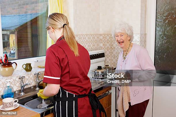 El Personal De Enfermería Y Happy Senior Mujer Haciendo Platos En La Cocina Foto de stock y más banco de imágenes de Asistente sanitario