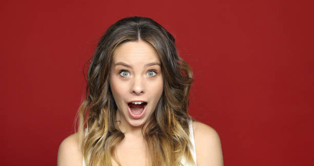 istock Female Face in Shock on red Close Up 957183722