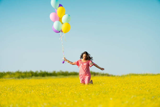 istock Smiling beautiful woman with balloons 957184076