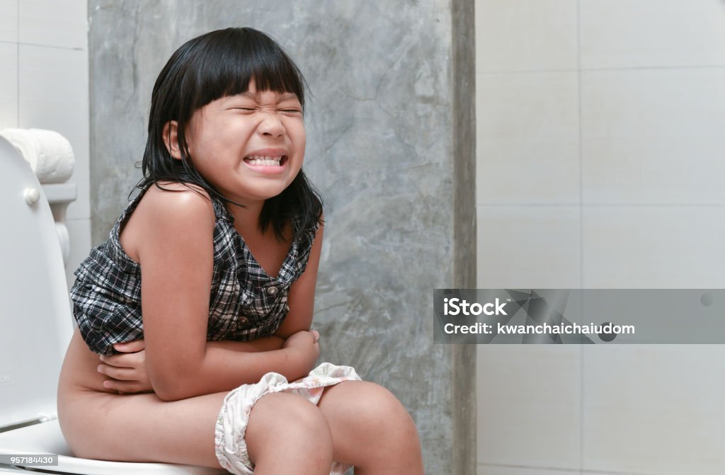 girl feel pain with constipation in the bathroom Asian girl feel pain with constipation in the bathroom, Healthy concept Child Stock Photo