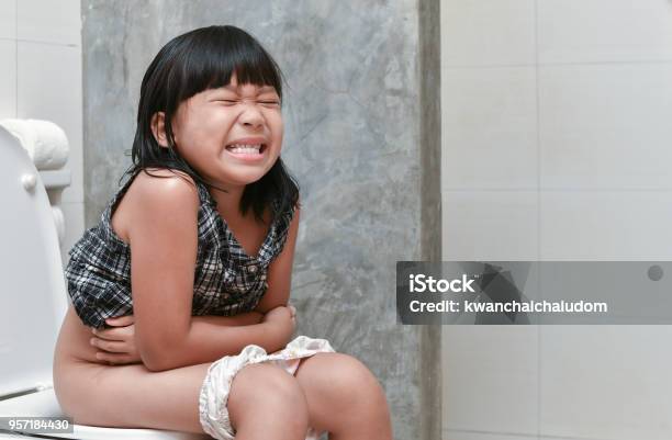Girl Feel Pain With Constipation In The Bathroom Stock Photo - Download Image Now - Child, Toilet, Constipation
