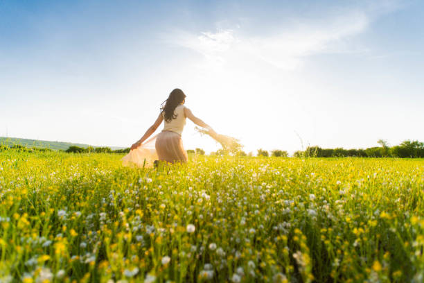 istock Woman running across a meadow at sunset 957187206