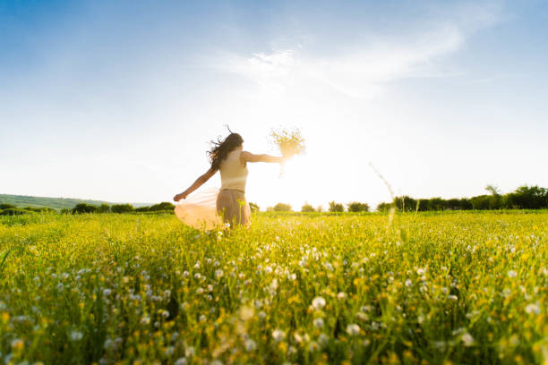 istock Woman running across a meadow at sunset 957187234