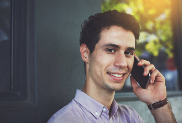 istock Smiling young man using his phone in the street 957187302