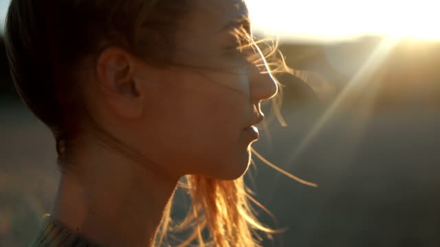 Close-up video of young woman looking thoughtfully into the distance.