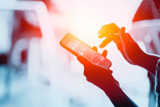 istock Business people using smartphone with to looking business chart on screen 957189882