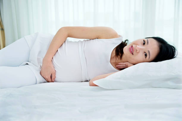 istock Pregnant woman sleeping in bed 957189974
