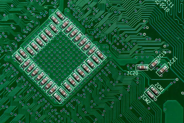 Photo of Ceramic Capacitors on Green Digital electronic circuit board texture pattern background