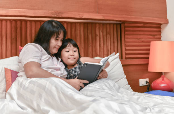 istock Young mother reading a book to her daughter. 957192932