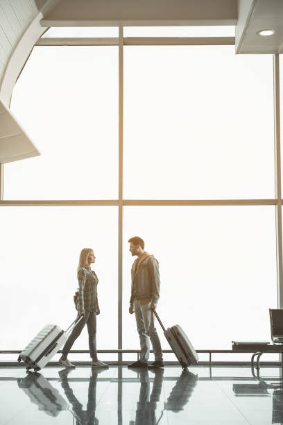 istock Happy girl talking with cheerful man in terminal 957193320