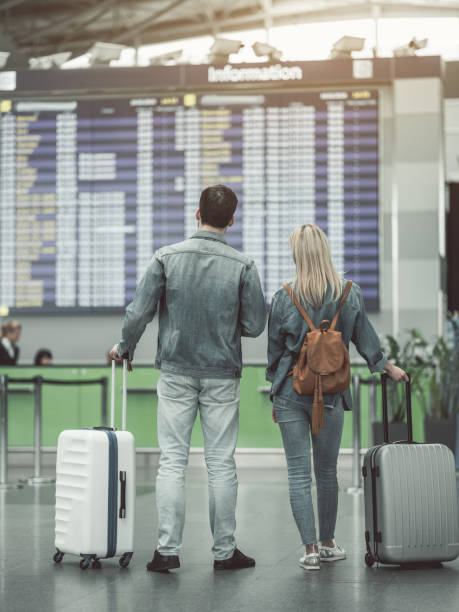 istock Woman and male watching at terminal board 957194410