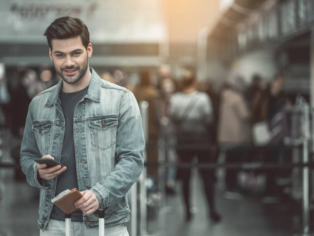 istock Satisfied traveler using modern phone in airport 957194636