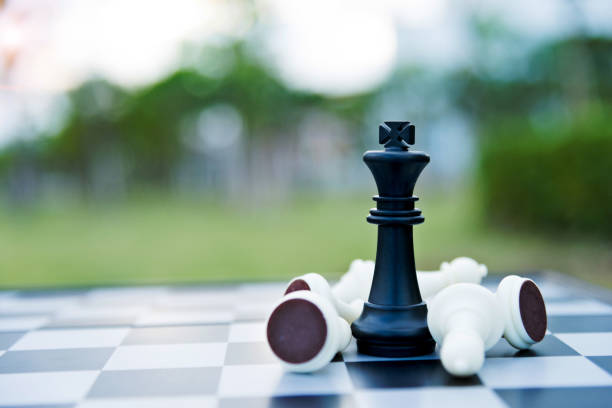 istock Black chess king among lying down white pawns 957203020