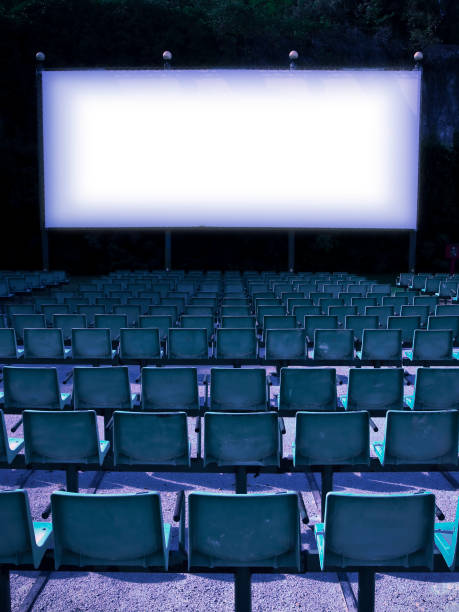 A row of neatly arranged red movie seats in an empty movie theater. Film industry.
