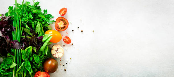 istock Fresh spinach,green onion, basil, herbs, dill and tomatoes on gray concrete background, selective focus. Top view. Toned effect. Food cooking ingredients. Vegan, raw, detox concept 957206978