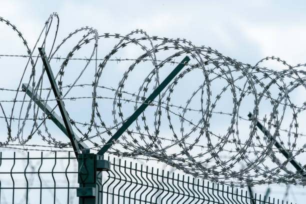 istock Security fence with a barbed wire. Fence with a barbed wire. 957211988
