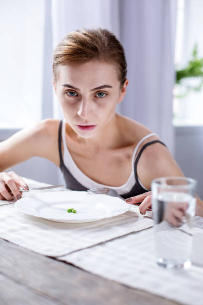 istock Cheerless pale woman sitting at the table 957217762