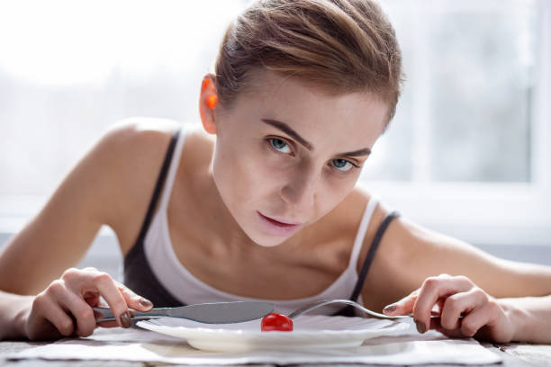 istock Pale underweight woman cutting a tomato 957218956