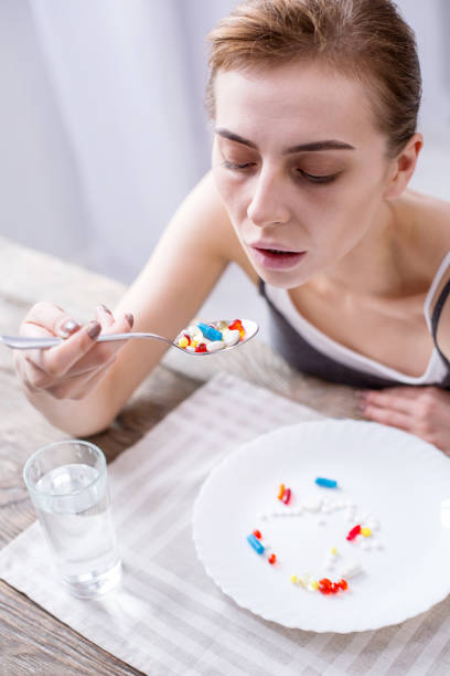istock Depressed young woman taking medicine 957219544