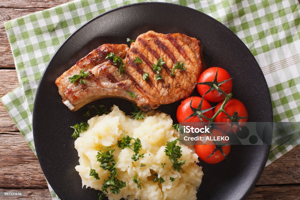 Grilled pork steak with mashed potatoes close-up. horizontal top view Grilled pork steak with mashed potatoes on a plate close-up. horizontal view from above Chopping Food Stock Photo