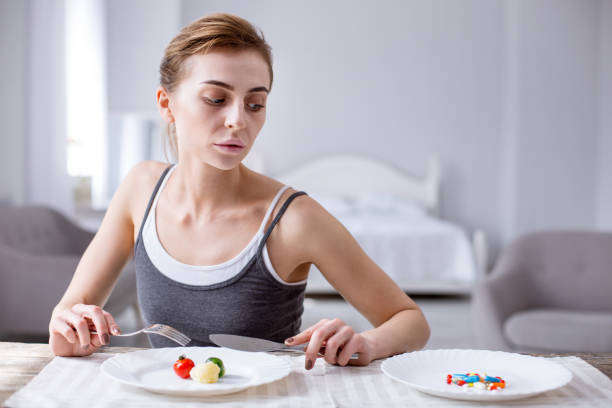 istock Sad depressed woman looking at the pills 957222102