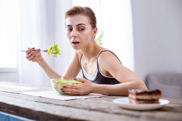 istock Depressed hungry woman looking at the cake 957223820