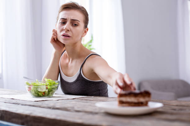 istock Depressed young woman wanting a cake 957223932