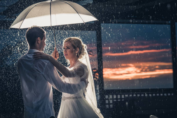 istock Loving newlyweds dancing on a rain under the umbrella. 957238646