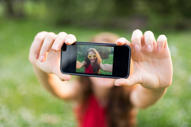 istock Lady taking a selfie in the park close-up 957240844