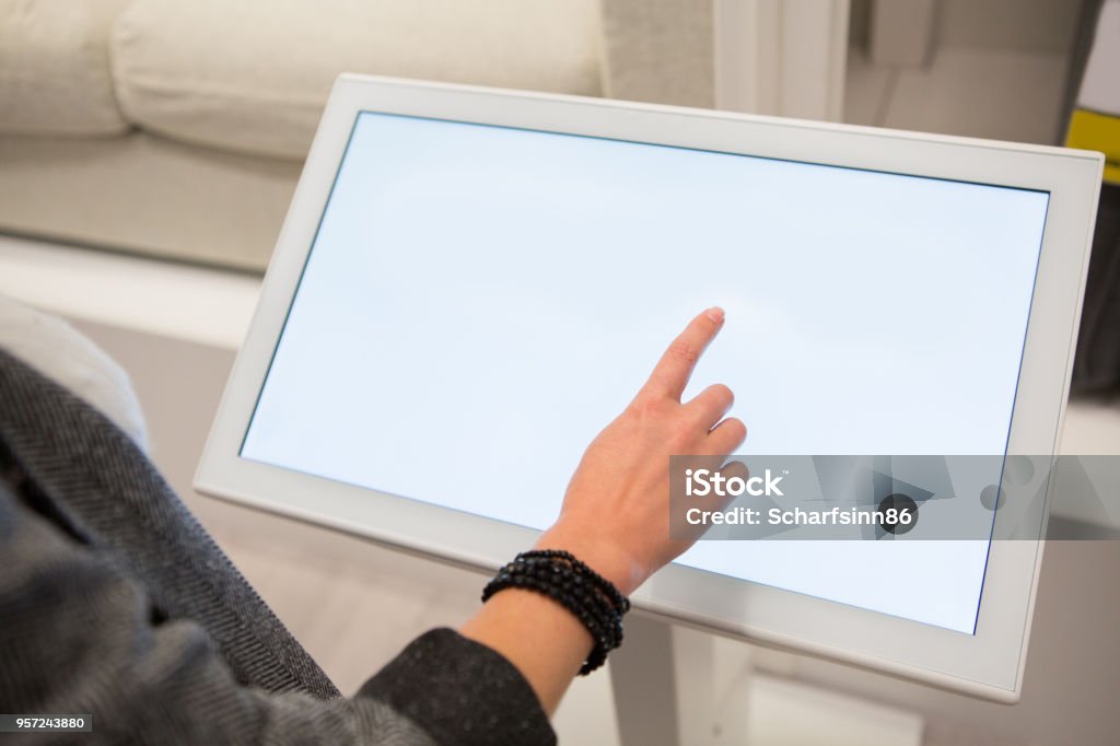 Woman with self-service device in the store Woman configuring furniture at the self-service device in the store Touch Screen Stock Photo