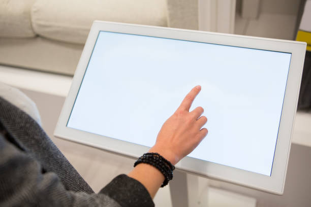 Woman with self-service device in the store Woman configuring furniture at the self-service device in the store kiosk stock pictures, royalty-free photos & images