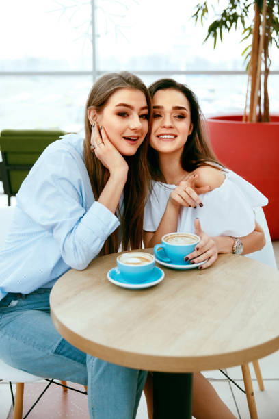 istock Girls Friends Drinking Coffee In Cafe 957244314