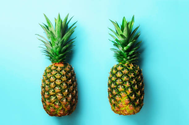 istock Fresh pineapples on blue background. Top View. Pop art design, creative concept. Copy Space. Bright pineapple pattern for minimal style 957245342
