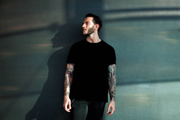 retrato de hombre joven tatuada con camiseta negra - mens shirt fotografías e imágenes de stock