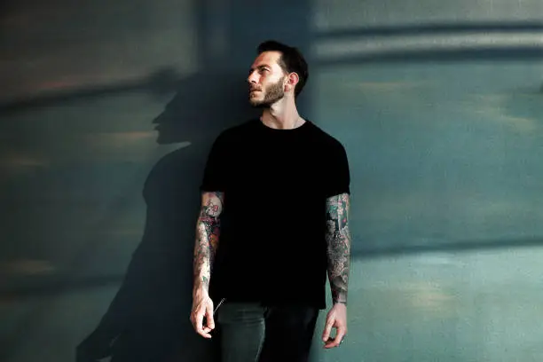 Photo of Portrait of tattooed young man with black t-shirt