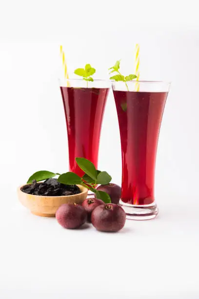 Photo of Kokum Sharbat, Juice or Sherbet OR summer coolant drink made up of Garcinia indica with raw fruit, served in a glass with mint leaf. selective focus