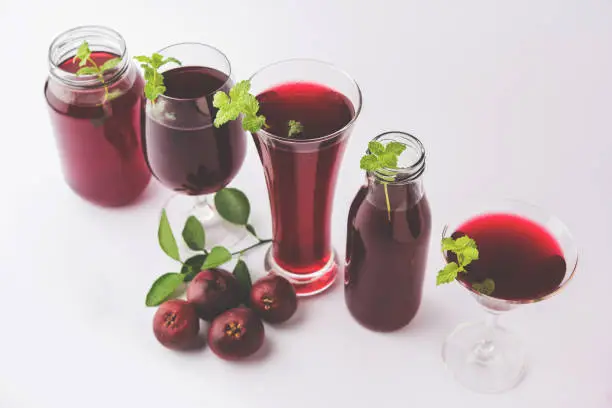 Photo of Kokum Sharbat, Juice or Sherbet OR summer coolant drink made up of Garcinia indica with raw fruit, served in a glass with mint leaf. selective focus