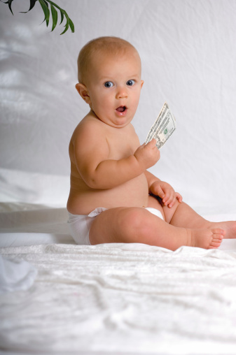 Cute baby holding paper money looking completely shocked. Could be used as a stricker shock concept, lottery win, banking, making money, tight with money, etc. 