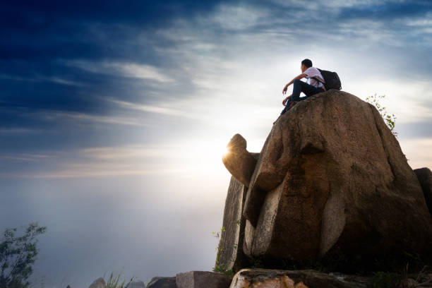 istock Man sitting on top of the mountain 957277520