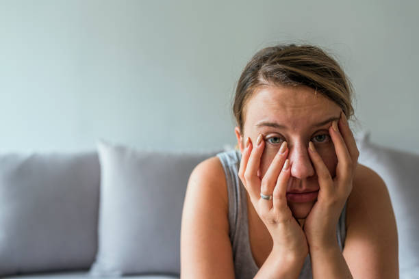 istock Sad young tired woman sitting on the bed 957285404