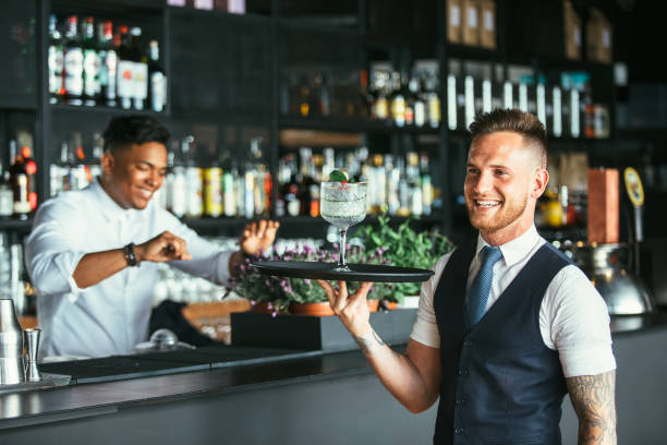 istock Smiling waiter with a cocktail 957289162